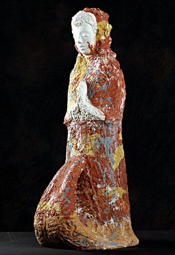 Kuvassa kivinen veistos, jossa rukoileva, hunnutettu nainen polvistuneena