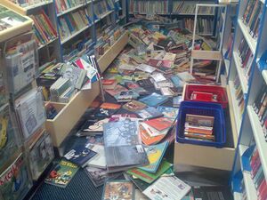 kuvassa näkymä kirjastoauton sisältä, jossa kirjat ovat tippuneet lattialle sekasotkuiseksi kasaksi