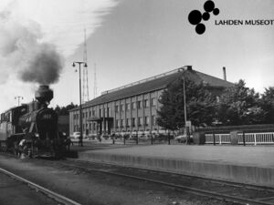 Kuvassa Lahden rautatieaseman päärakennus ja asemalle saapuva höyryjuna, 1954.